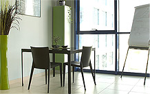Instalaciones de Websmultimedia. Zona de reuniones: Una mesa negra con 3 sillas de diseño negras.